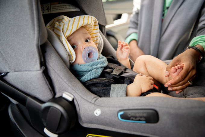 Parent putting baby in car seat